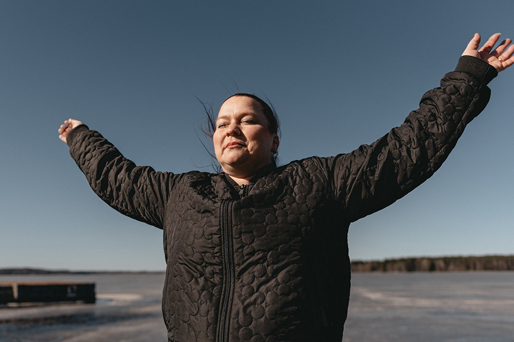Hanne seisoo ulkona silmät kiinni ja kädet levitettyinä.